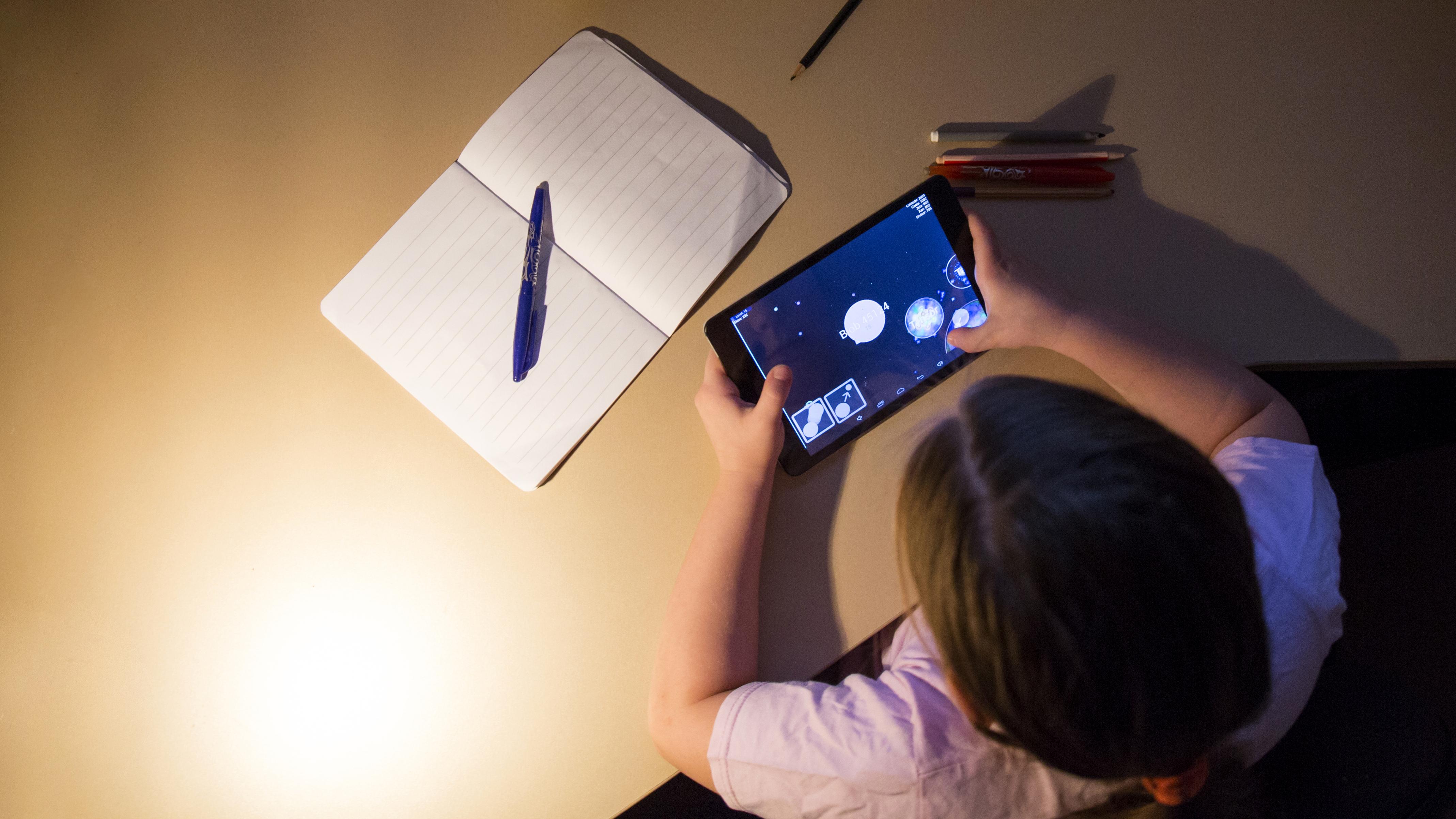 girl-playing-tablet-game-evening